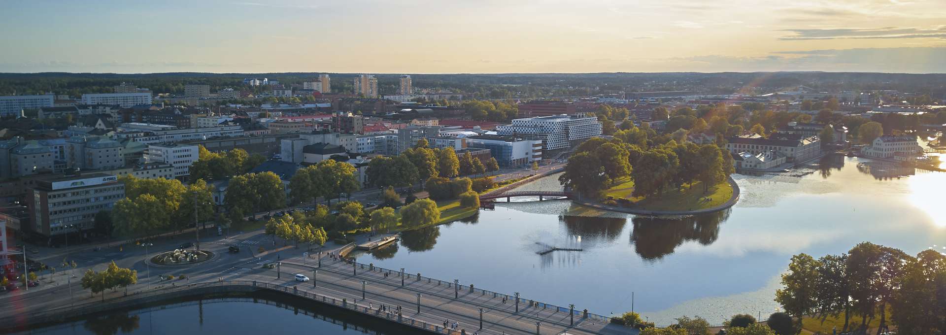 Aerial view of Eskilstuna at sunset showing the cityscape, rivers, and bridges.n univerity and greenery